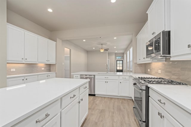 119 Lukewood Cir, Conroe, TX 77318 - kitchen featuring appliances with stainless steel finishes, a sink, light countertops, recessed lighting, and white cabinetry