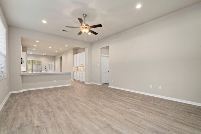119 Lukewood Cir, Conroe, TX 77318 - unfurnished living room with ceiling fan, light wood-style floors, baseboards, recessed lighting, and a sink