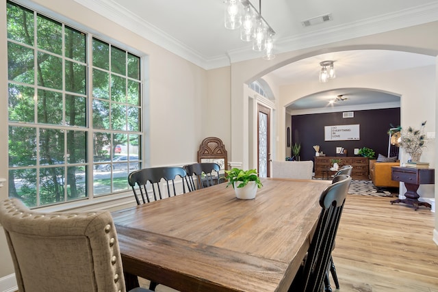 3006 Pecan Way Ct, Richmond, TX 77406 - dining space with arched walkways, light wood finished floors, and ornamental molding