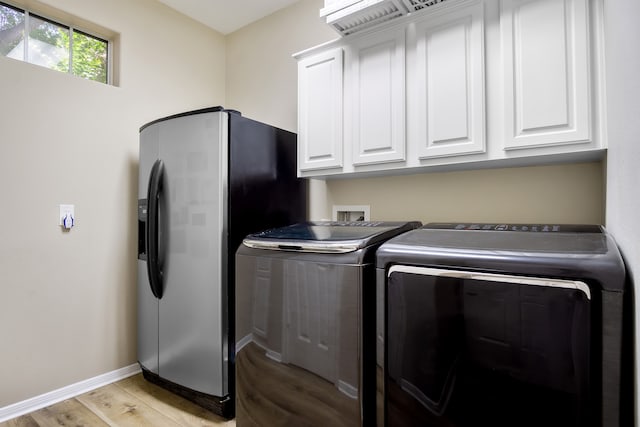 3006 Pecan Way Ct, Richmond, TX 77406 - laundry area with washing machine and dryer, cabinet space, light wood-style floors, and baseboards