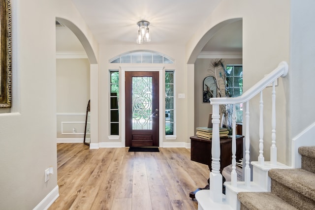 3006 Pecan Way Ct, Richmond, TX 77406 - foyer entrance featuring stairway, wood-type flooring, healthy amount of natural light, arched walkways, and crown molding