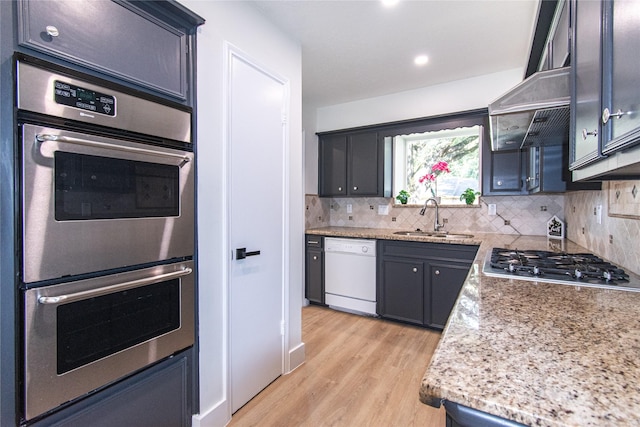 822 Red Rock Canyon Dr, Katy, TX 77450 - kitchen with appliances with stainless steel finishes, light wood-style floors, extractor fan, tasteful backsplash, and recessed lighting