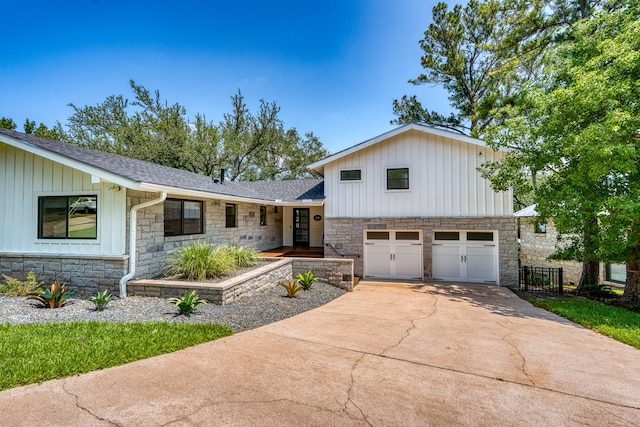 204 Blue Waters Dr, Horseshoe Bay, TX 78657 - tri-level home with stone siding, driveway, a garage, board and batten siding, and roof with shingles