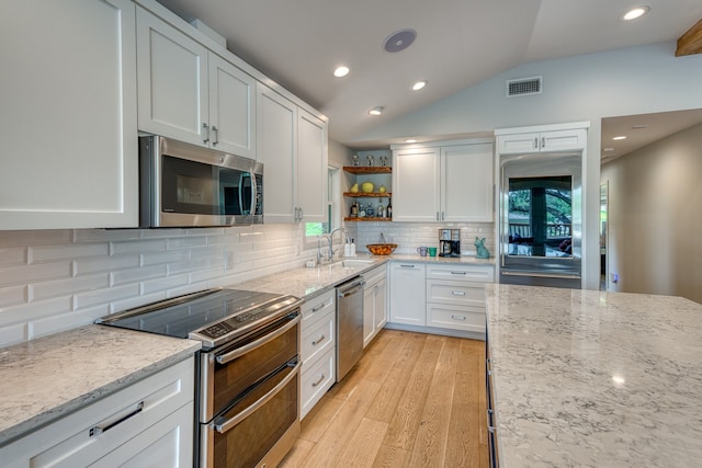 204 Blue Waters Dr, Horseshoe Bay, TX 78657 - kitchen with stainless steel appliances, open shelves, white cabinets, a sink, and vaulted ceiling