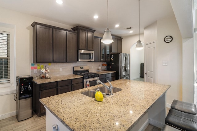 2715 Wembley Way, Rosenberg, TX 77471 - kitchen with appliances with stainless steel finishes, a sink, dark brown cabinetry, decorative backsplash, and baseboards
