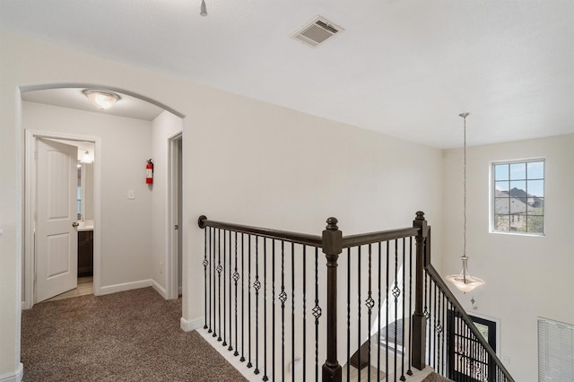 2715 Wembley Way, Rosenberg, TX 77471 - hallway featuring an upstairs landing, arched walkways, carpet, and baseboards