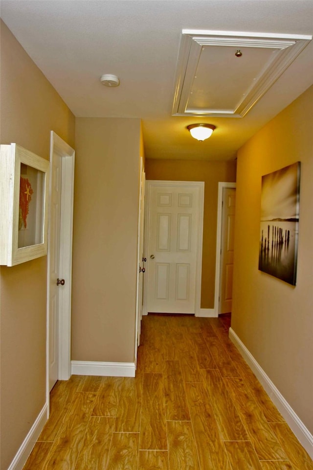 13015 Gulf Beach Dr, Freeport, TX 77541 - hallway featuring attic access, wood finished floors, and baseboards