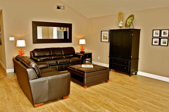 13015 Gulf Beach Dr, Freeport, TX 77541 - living area featuring baseboards, light wood-type flooring, and vaulted ceiling