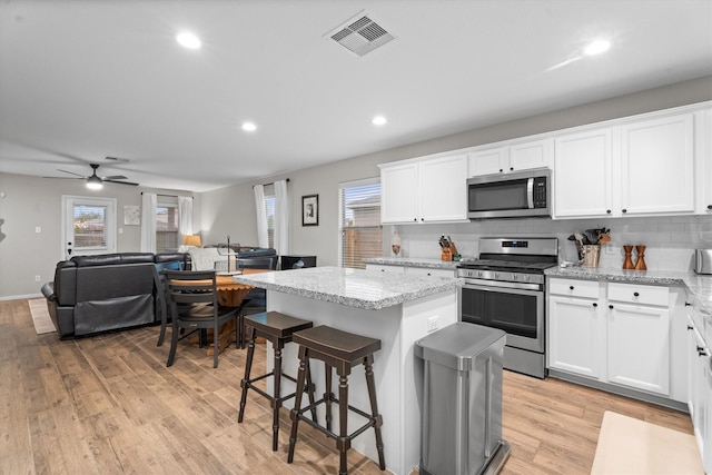 21343 Slate Crossing Ln, Katy, TX 77449 - kitchen featuring appliances with stainless steel finishes, a center island, white cabinets, and recessed lighting