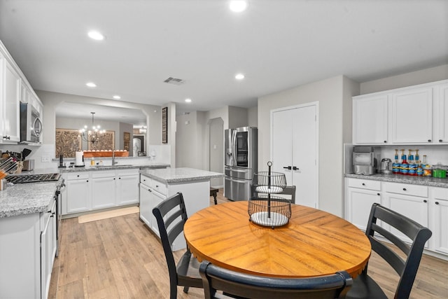 21343 Slate Crossing Ln, Katy, TX 77449 - dining area with recessed lighting, light wood-type flooring, a chandelier, and arched walkways