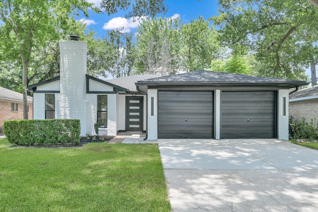 5015 Monteith Dr, Spring, TX 77373 - view of front of property with concrete driveway, a chimney, a front lawn, and a garage