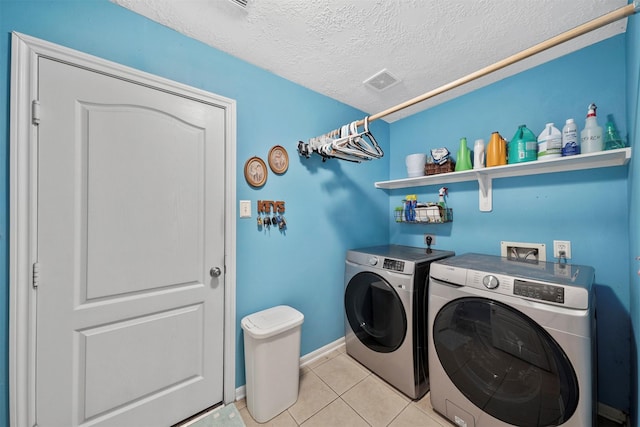 1497 Allison St, Alvin, TX 77511 - laundry room with independent washer and dryer, light tile patterned floors, a textured ceiling, and baseboards