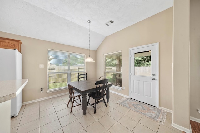1497 Allison St, Alvin, TX 77511 - dining room with baseboards, lofted ceiling, light tile patterned floors, and a textured ceiling