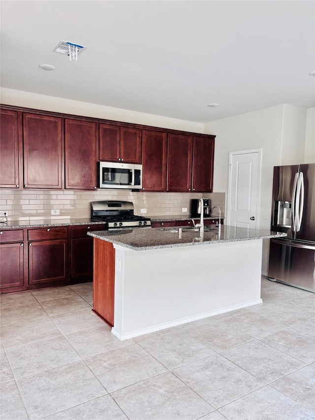 5130 Klein Orchard Dr, Houston, TX 77066 - kitchen with appliances with stainless steel finishes, reddish brown cabinets, dark stone counters, and tasteful backsplash