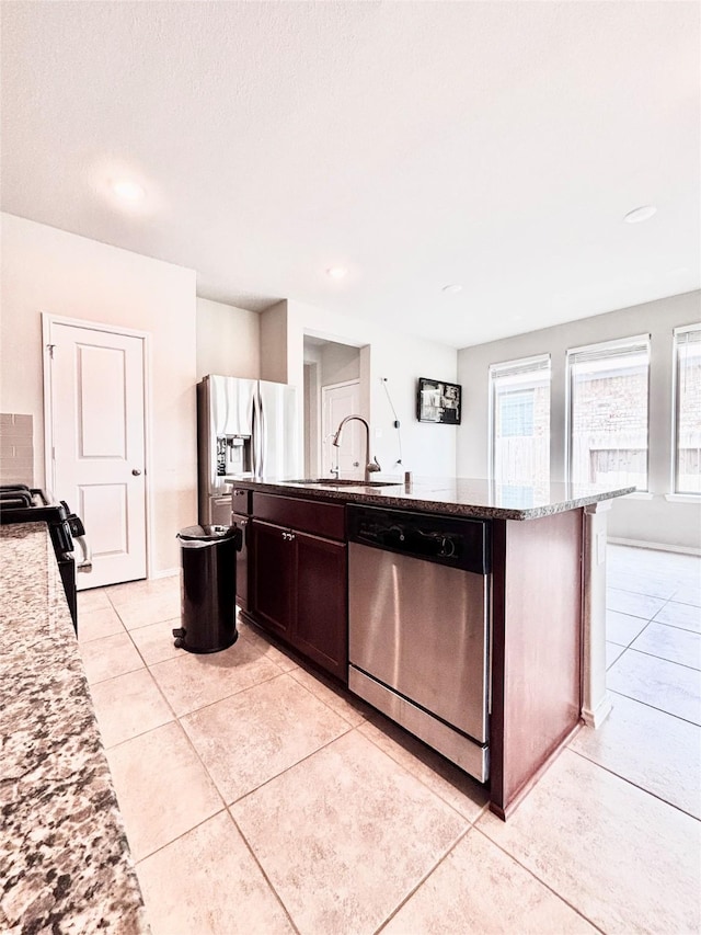 5130 Klein Orchard Dr, Houston, TX 77066 - kitchen featuring appliances with stainless steel finishes, a sink, a kitchen island with sink, light tile patterned floors, and stone countertops