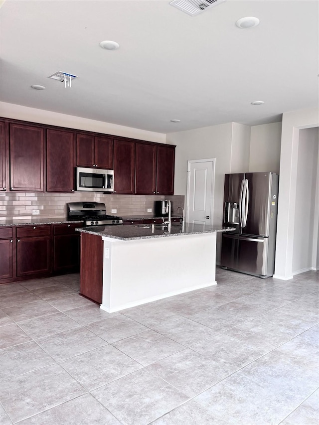 5130 Klein Orchard Dr, Houston, TX 77066 - kitchen featuring stainless steel appliances, decorative backsplash, stone counters, a kitchen island with sink, and light tile patterned floors