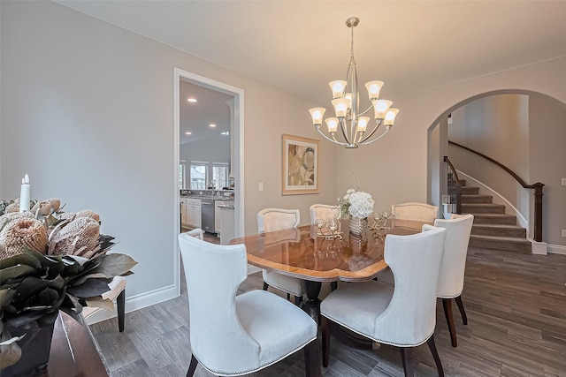 27923 Coulter Dr, Spring, TX 77386 - dining room featuring arched walkways, a chandelier, wood finished floors, and stairs