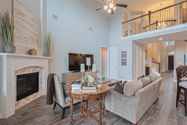 27923 Coulter Dr, Spring, TX 77386 - living room featuring a ceiling fan, stairs, a towering ceiling, a glass covered fireplace, and wood finished floors