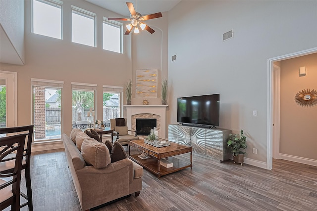 27923 Coulter Dr, Spring, TX 77386 - living area featuring a towering ceiling, a ceiling fan, wood finished floors, and a fireplace