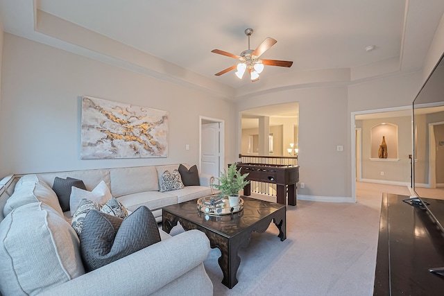 27923 Coulter Dr, Spring, TX 77386 - living room featuring light carpet, a ceiling fan, a raised ceiling, and arched walkways