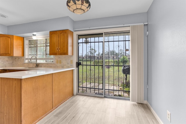 3919 Gardendale Dr, Houston, TX 77092 - kitchen featuring a sink, decorative backsplash, light countertops, and brown cabinets