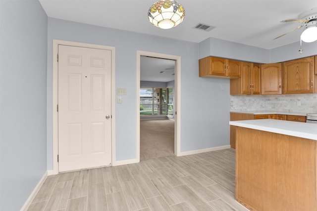 3919 Gardendale Dr, Houston, TX 77092 - kitchen with light countertops, a ceiling fan, brown cabinets, baseboards, and light wood finished floors