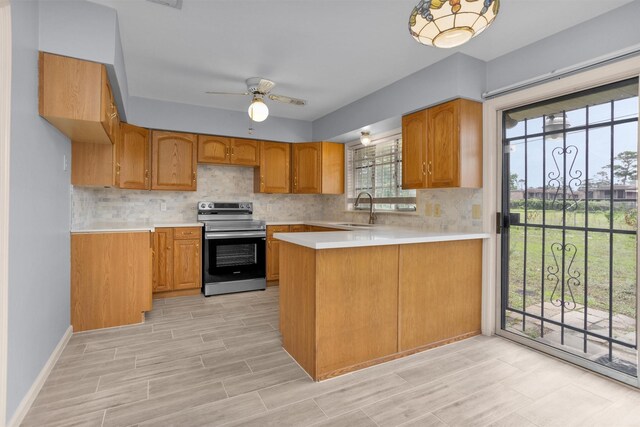 3919 Gardendale Dr, Houston, TX 77092 - kitchen with stainless steel electric range oven, a sink, light countertops, a peninsula, and decorative backsplash