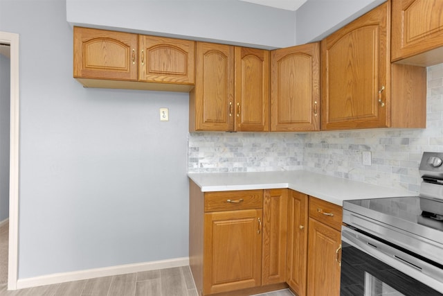 3919 Gardendale Dr, Houston, TX 77092 - kitchen featuring electric stove, light countertops, backsplash, baseboards, and brown cabinets
