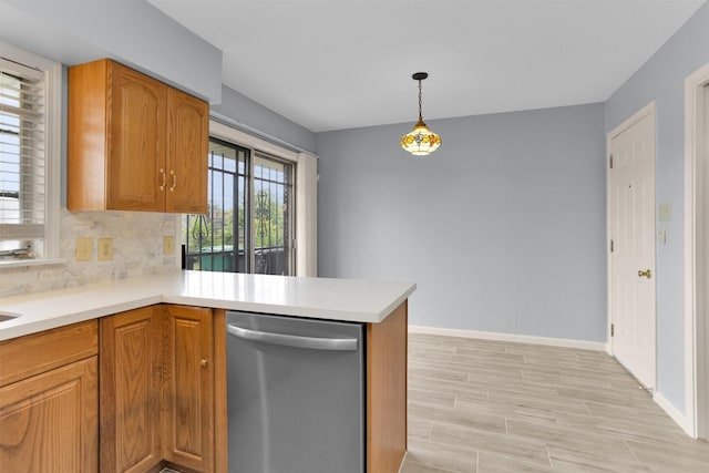 3919 Gardendale Dr, Houston, TX 77092 - kitchen featuring stainless steel dishwasher, backsplash, light countertops, baseboards, and a peninsula