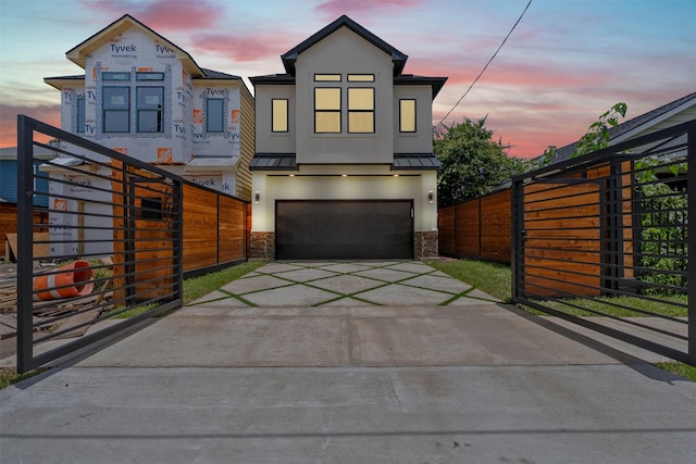 6613 Ave O, Houston, TX 77011 - view of front of property with a standing seam roof, concrete driveway, stucco siding, and a garage