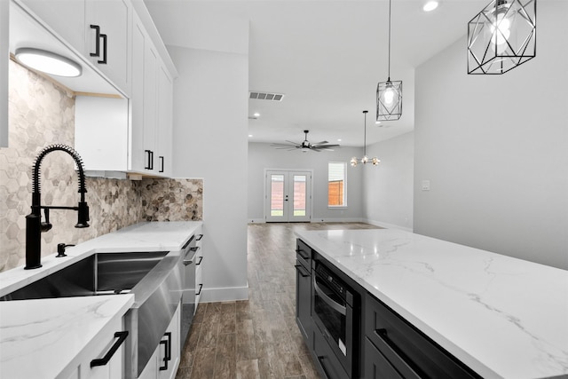 6613 Ave O, Houston, TX 77011 - kitchen featuring white cabinets, dark wood-style flooring, backsplash, recessed lighting, and pendant lighting