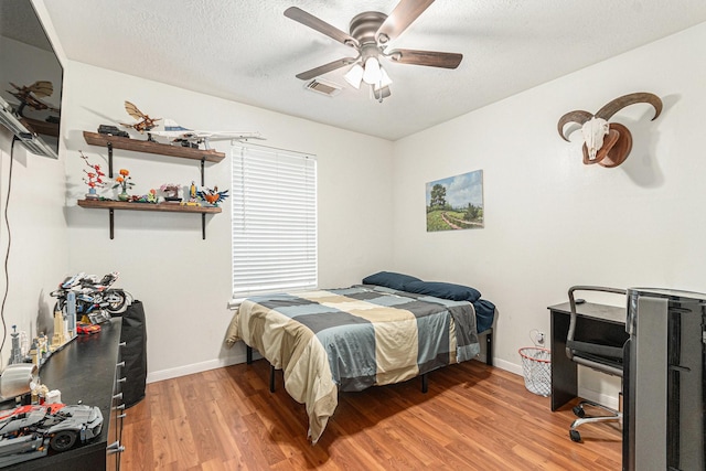 10922 Graywood Ct, La Porte, TX 77571 - bedroom with light wood-style floors, a ceiling fan, baseboards, and a textured ceiling