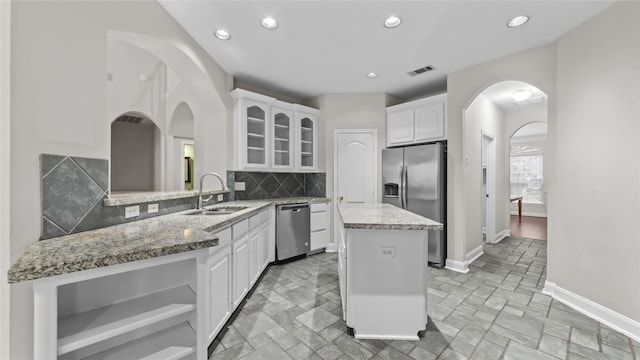 9710 Sotherloch Lake Dr, Spring, TX 77379 - kitchen with stainless steel appliances, a sink, glass insert cabinets, baseboards, and a kitchen island