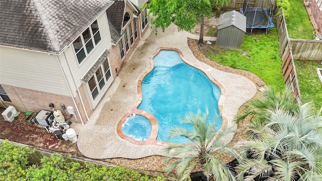 9710 Sotherloch Lake Dr, Spring, TX 77379 - view of swimming pool featuring a trampoline, a fenced backyard, and a pool with connected hot tub