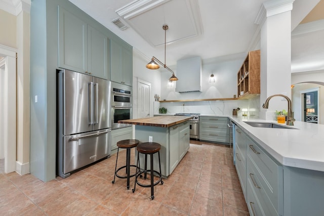 11710 Creek View Ln, Conroe, TX 77385 - kitchen featuring premium appliances, wood counters, a sink, open shelves, and ornamental molding