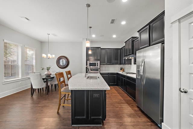 2027 Tarfite Pl, Houston, TX 77077 - kitchen featuring stainless steel appliances, a center island with sink, backsplash, a sink, and light stone countertops