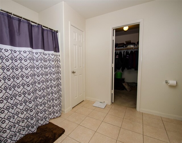 9414 Emerald Green Dr, Rosharon, TX 77583 - bathroom with curtained shower, tile patterned flooring, and baseboards