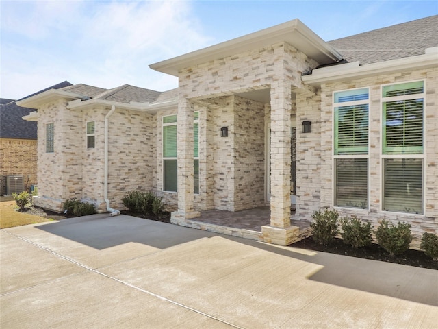 236 Bentwood Dr, Montgomery, TX 77356 - property entrance featuring central AC unit, a patio, and roof with shingles