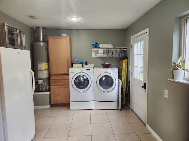 27491 Lantern Ln, New Caney, TX 77357 - washroom featuring water heater, cabinet space, independent washer and dryer, light tile patterned floors, and a textured ceiling