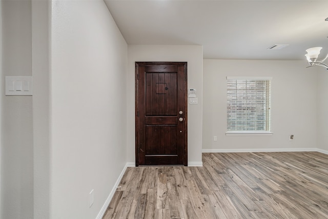 9914 Sageroyal Ln, Houston, TX 77089 - entryway with light wood-style flooring, a chandelier, and baseboards