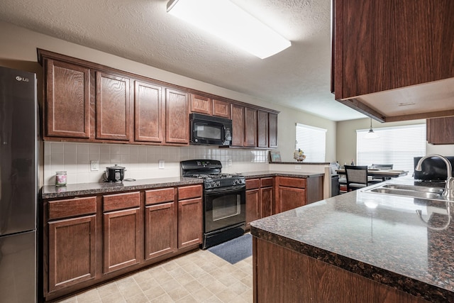 934 Sage St, Baytown, TX 77521 - kitchen featuring black appliances, a sink, dark countertops, and a textured ceiling