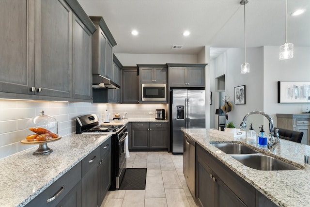 6903 Aspen Peak Dr, Baytown, TX 77521 - kitchen featuring stainless steel appliances, a sink, decorative backsplash, light stone countertops, and decorative light fixtures