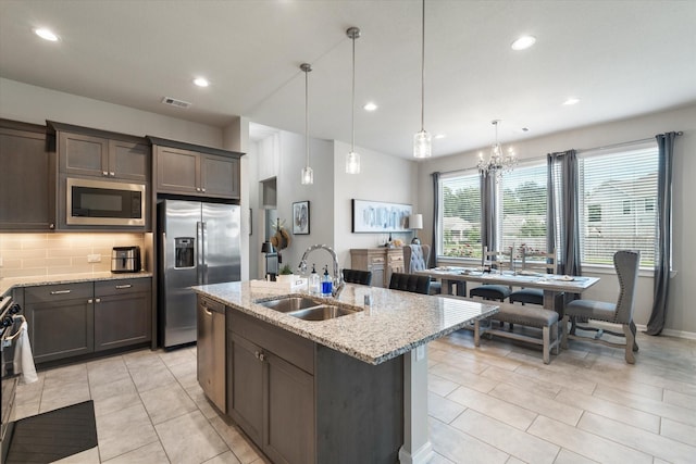 6903 Aspen Peak Dr, Baytown, TX 77521 - kitchen featuring stainless steel appliances, a sink, a chandelier, dark brown cabinets, and recessed lighting