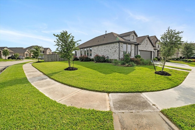 6903 Aspen Peak Dr, Baytown, TX 77521 - view of home's exterior featuring a yard, a residential view, a garage, concrete driveway, and brick siding