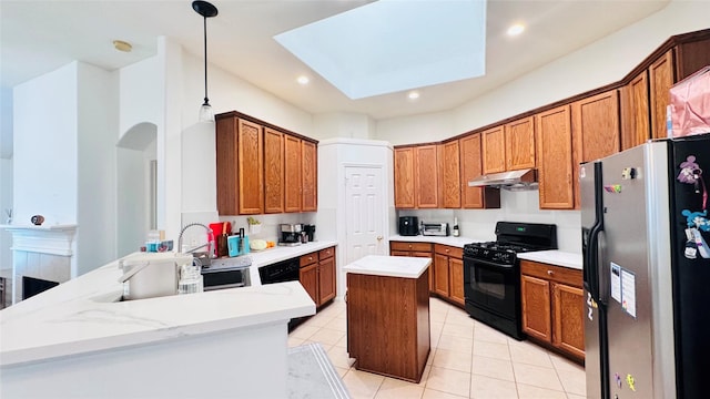 25023 Ivy Trace Ln, Katy, TX 77494 - kitchen with black gas range oven, stainless steel fridge, light tile patterned floors, a skylight, and a peninsula
