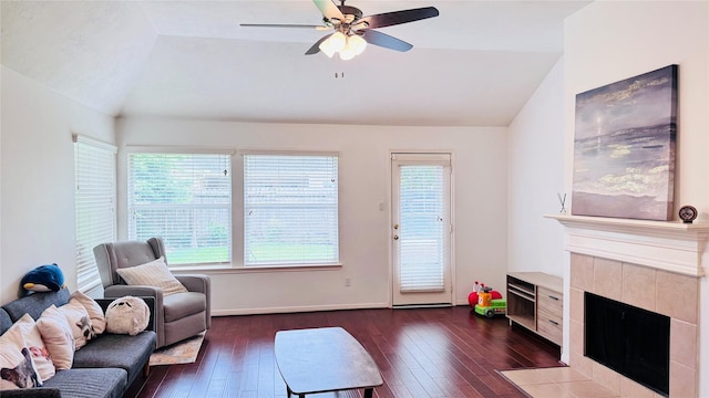 25023 Ivy Trace Ln, Katy, TX 77494 - living room featuring lofted ceiling, dark wood-type flooring, a tiled fireplace, ceiling fan, and baseboards