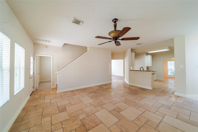 19422 Harvest Stream Way, Houston, TX 77084 - unfurnished living room with stone tile flooring, healthy amount of natural light, a ceiling fan, and stairway