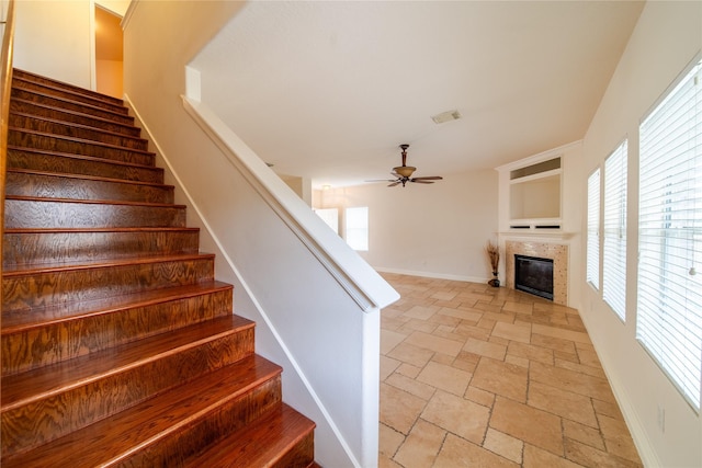 19422 Harvest Stream Way, Houston, TX 77084 - staircase featuring stone tile floors, ceiling fan, a tiled fireplace, and baseboards