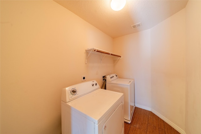 19422 Harvest Stream Way, Houston, TX 77084 - laundry area with separate washer and dryer, wood finished floors, baseboards, and a textured ceiling