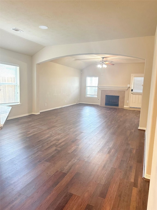 8239 Polaris Point Ln, Cypress, TX 77433 - unfurnished living room with lofted ceiling, dark wood-style floors, ceiling fan, arched walkways, and a fireplace